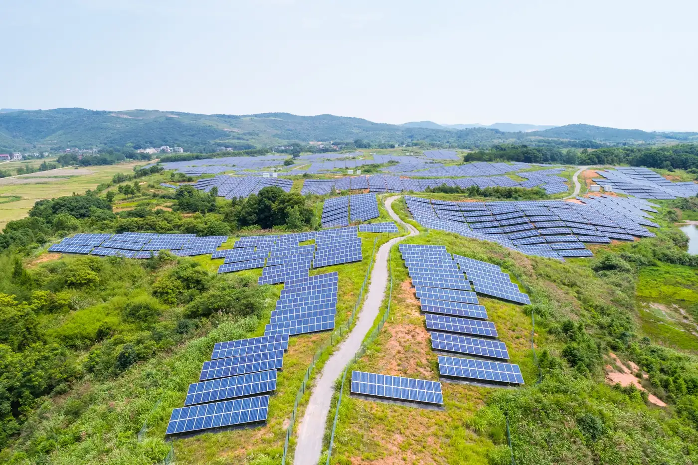 Ein Solarpark auf grünen Hügeln, aus der Luft gesehen